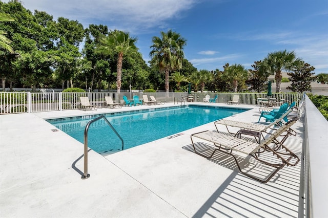 community pool with fence and a patio