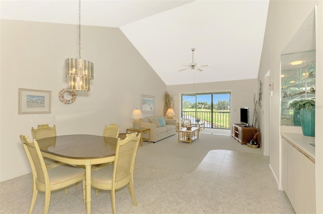 dining space featuring ceiling fan with notable chandelier, high vaulted ceiling, and light carpet