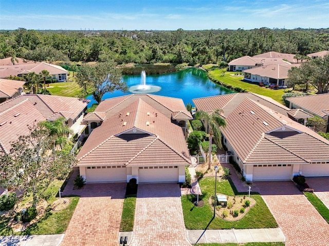 birds eye view of property featuring a water view, a residential view, and a wooded view