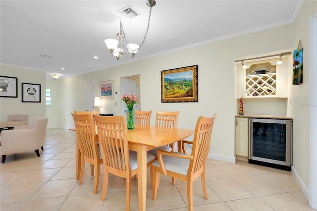 dining space with light tile patterned floors, visible vents, ornamental molding, a bar, and beverage cooler