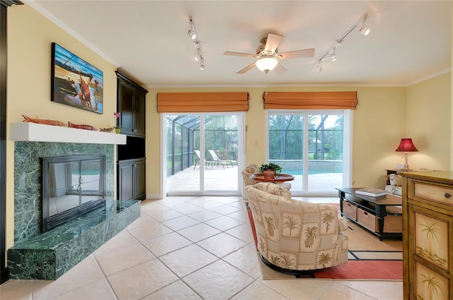 living area with a premium fireplace, a wealth of natural light, and crown molding