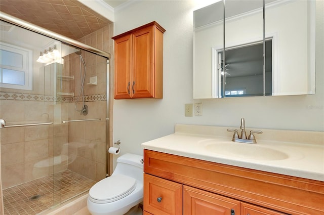 bathroom with ornamental molding, a shower stall, toilet, and vanity