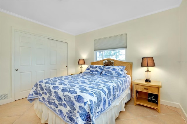 bedroom with ornamental molding, a closet, baseboards, and light tile patterned floors