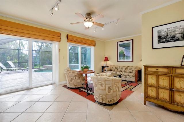 living area featuring light tile patterned floors, rail lighting, a ceiling fan, and crown molding