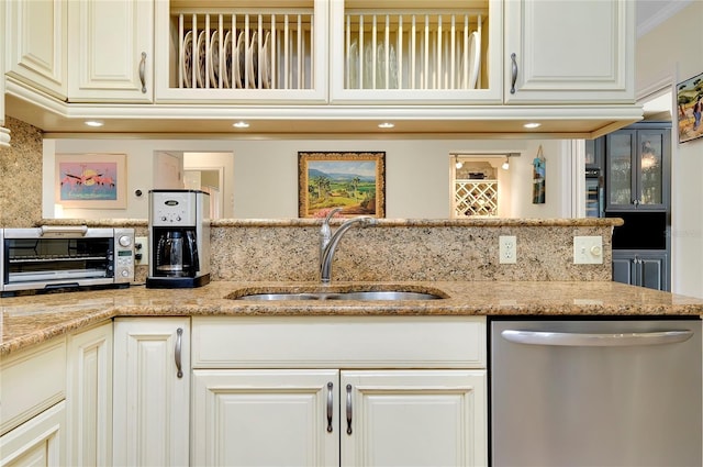 kitchen with light stone counters, a toaster, crown molding, stainless steel dishwasher, and a sink