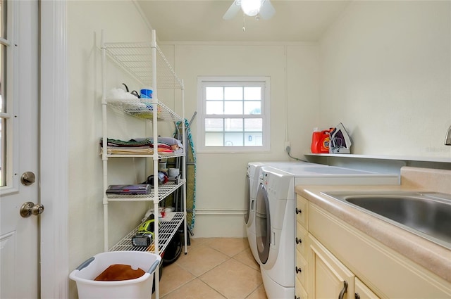 washroom featuring cabinet space, light tile patterned floors, and washing machine and clothes dryer