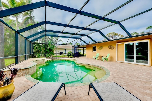 pool featuring glass enclosure and a patio area