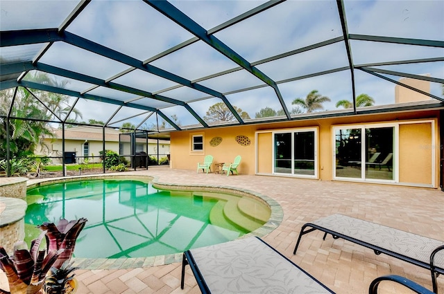 outdoor pool with a lanai and a patio area