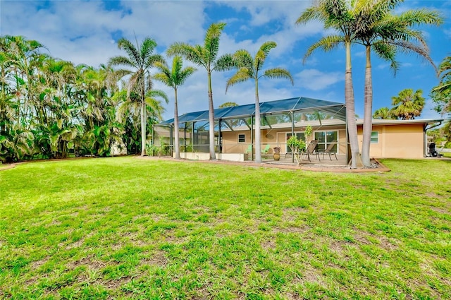 back of property featuring a lawn, a patio area, a lanai, and stucco siding