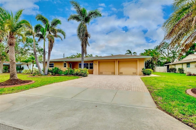 ranch-style house featuring a garage, decorative driveway, a front lawn, and stucco siding