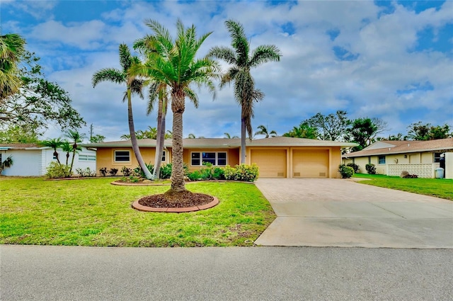 ranch-style house featuring decorative driveway, an attached garage, a front lawn, and stucco siding