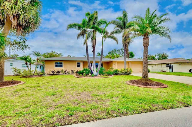 ranch-style house featuring a garage, a front yard, concrete driveway, and stucco siding