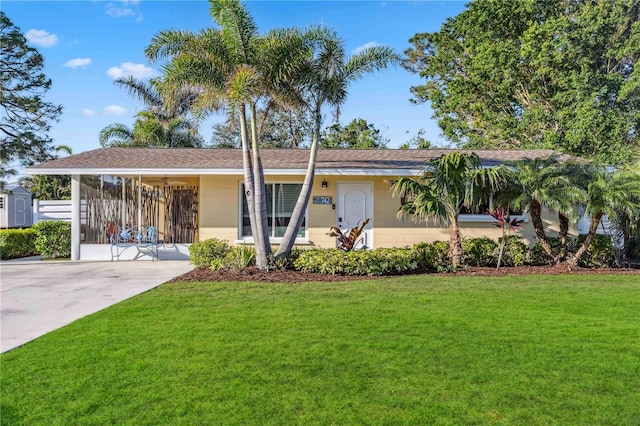 ranch-style home with an attached carport, concrete driveway, and a front yard