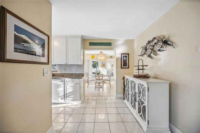 hallway with light tile patterned floors and baseboards