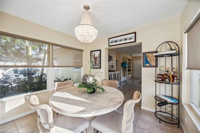 dining area featuring a chandelier, baseboards, and light tile patterned floors