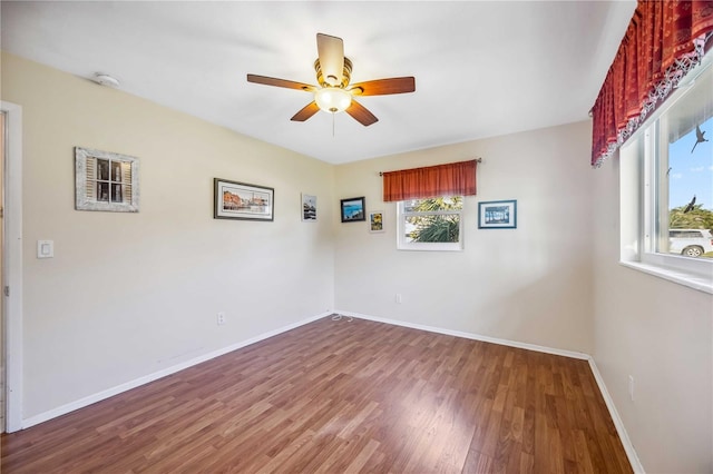 empty room featuring ceiling fan, wood finished floors, and baseboards