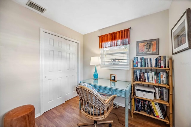 home office featuring baseboards, visible vents, and wood finished floors