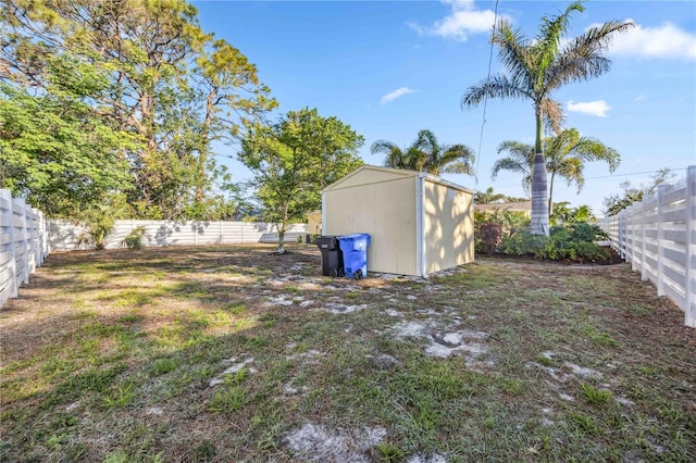 view of yard with an outbuilding, a shed, and a fenced backyard