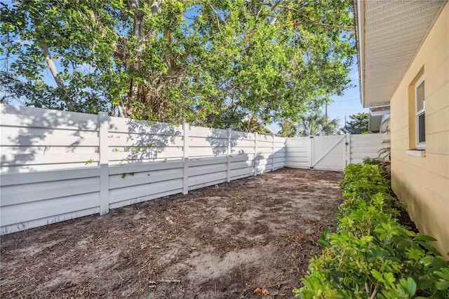 view of yard featuring a fenced backyard and a gate