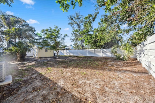 view of yard featuring a storage shed, an outdoor structure, and a fenced backyard