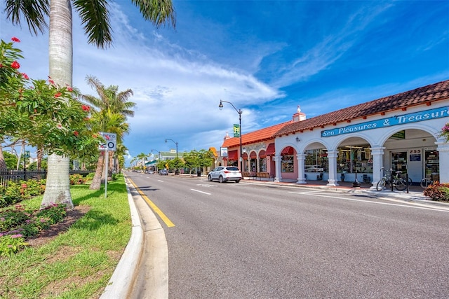 view of street with street lights, curbs, and sidewalks