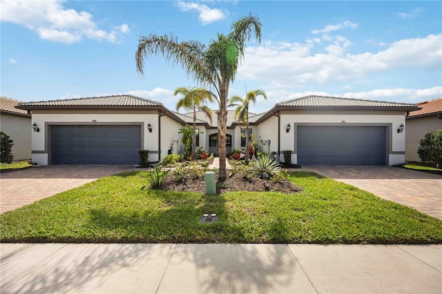 view of front of property featuring an attached garage, a tiled roof, decorative driveway, and stucco siding