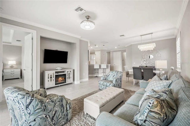13867 Vadini St, Venice, FL 34293 - living area with a glass covered fireplace, visible vents, baseboards, and crown molding