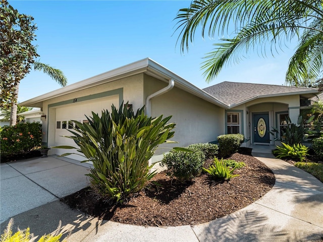 view of front of house with a garage, driveway, a shingled roof, and stucco siding