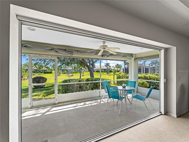 unfurnished sunroom featuring ceiling fan