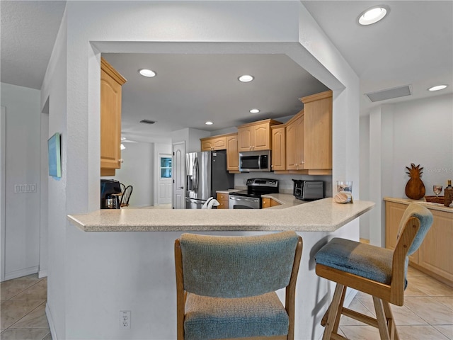 kitchen featuring stainless steel appliances, recessed lighting, light countertops, and light tile patterned flooring