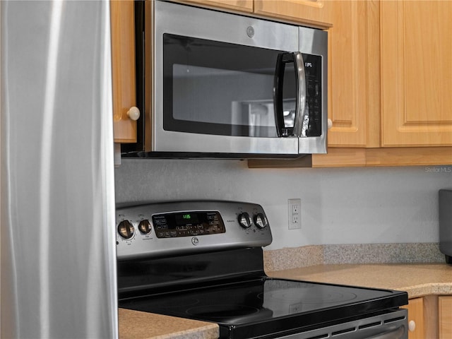 kitchen featuring light brown cabinets, stainless steel appliances, and light countertops