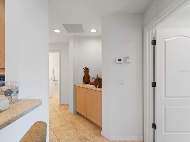 corridor with baseboards, light tile patterned flooring, visible vents, and recessed lighting