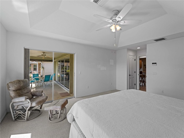 bedroom featuring carpet floors, access to outside, visible vents, and a tray ceiling