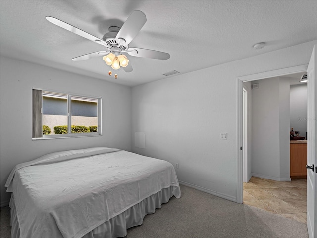 bedroom featuring a textured ceiling, ceiling fan, light colored carpet, visible vents, and baseboards