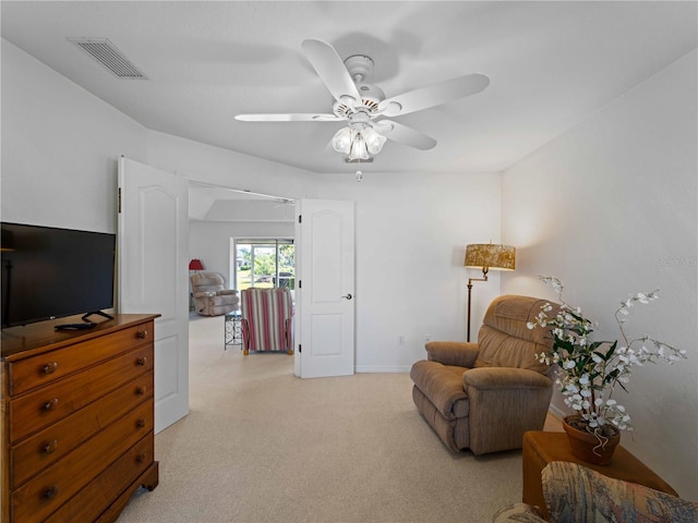 living area featuring visible vents, a ceiling fan, and light colored carpet