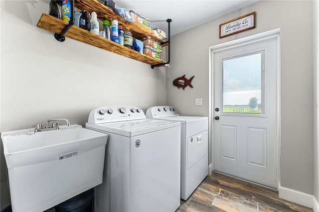 laundry room featuring dark wood-style flooring, washer and clothes dryer, a sink, laundry area, and baseboards