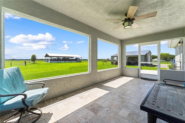 unfurnished sunroom featuring a wealth of natural light and ceiling fan