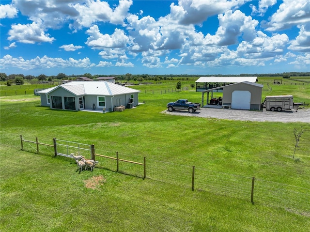 view of yard with a carport, a rural view, and fence