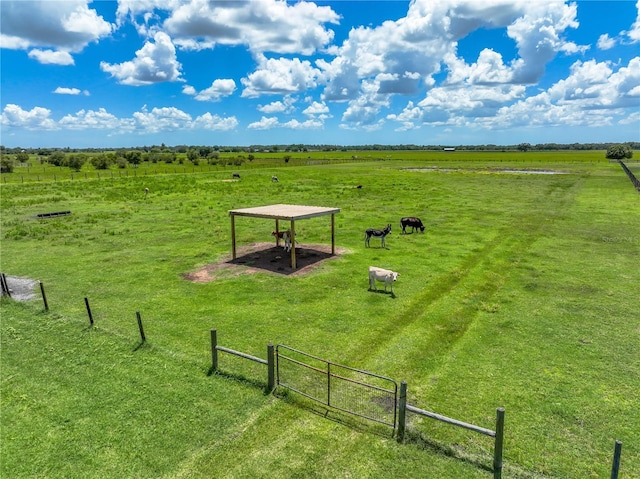 view of home's community featuring a yard, fence, and a rural view