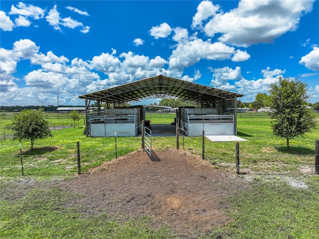 view of community featuring an outbuilding, a carport, a rural view, and an exterior structure