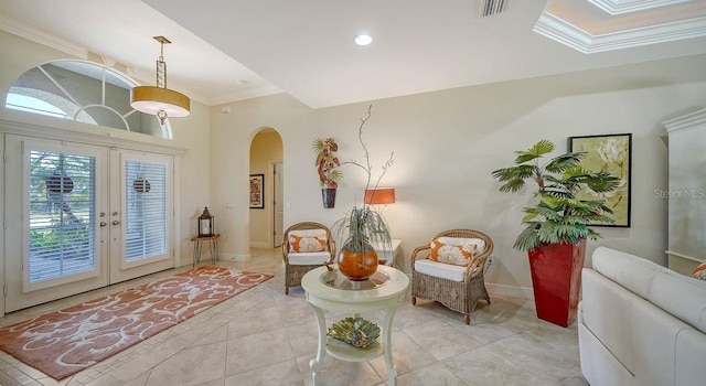 living area with visible vents, arched walkways, baseboards, and ornamental molding