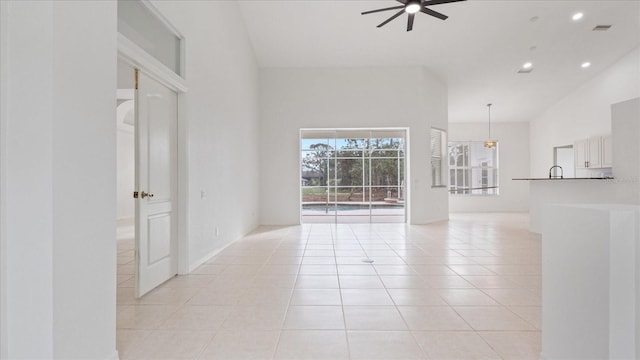 unfurnished living room featuring light tile patterned floors, ceiling fan, recessed lighting, a high ceiling, and visible vents