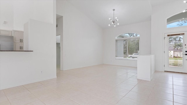 unfurnished dining area featuring light tile patterned floors, high vaulted ceiling, baseboards, and a notable chandelier