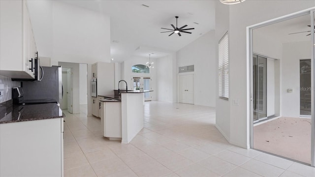 kitchen with stainless steel appliances, white cabinets, and a ceiling fan