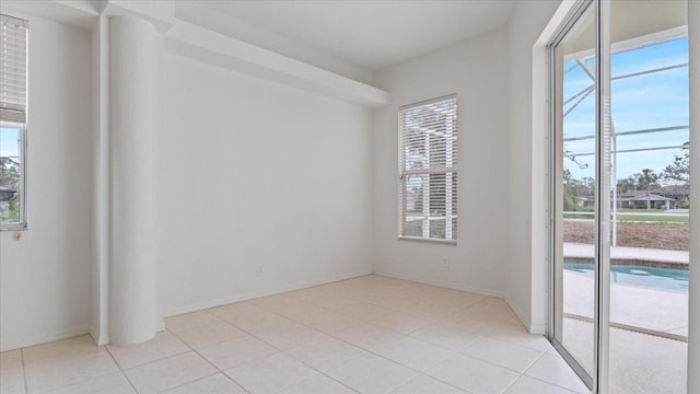 unfurnished room featuring baseboards and light tile patterned flooring