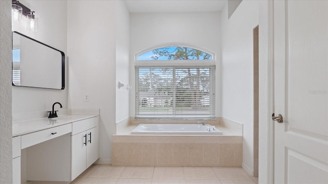 bathroom with a garden tub, vanity, and tile patterned floors