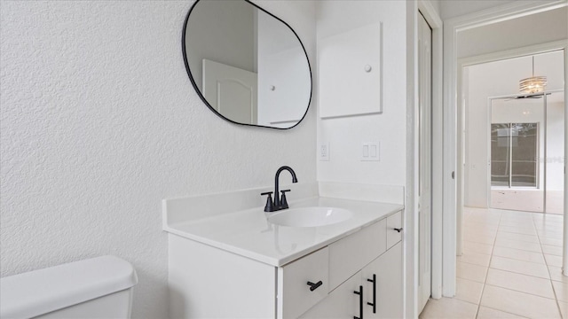 half bathroom with vanity, tile patterned flooring, and toilet