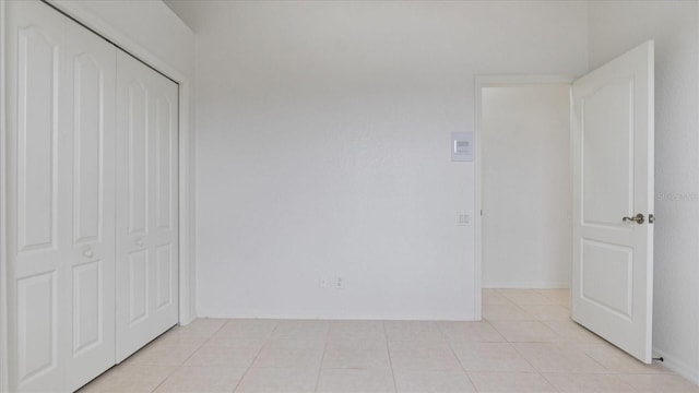 unfurnished bedroom featuring light tile patterned floors and a closet