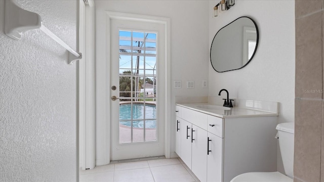 bathroom with toilet, tile patterned flooring, and vanity