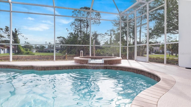 pool with a lanai, a patio area, and an in ground hot tub